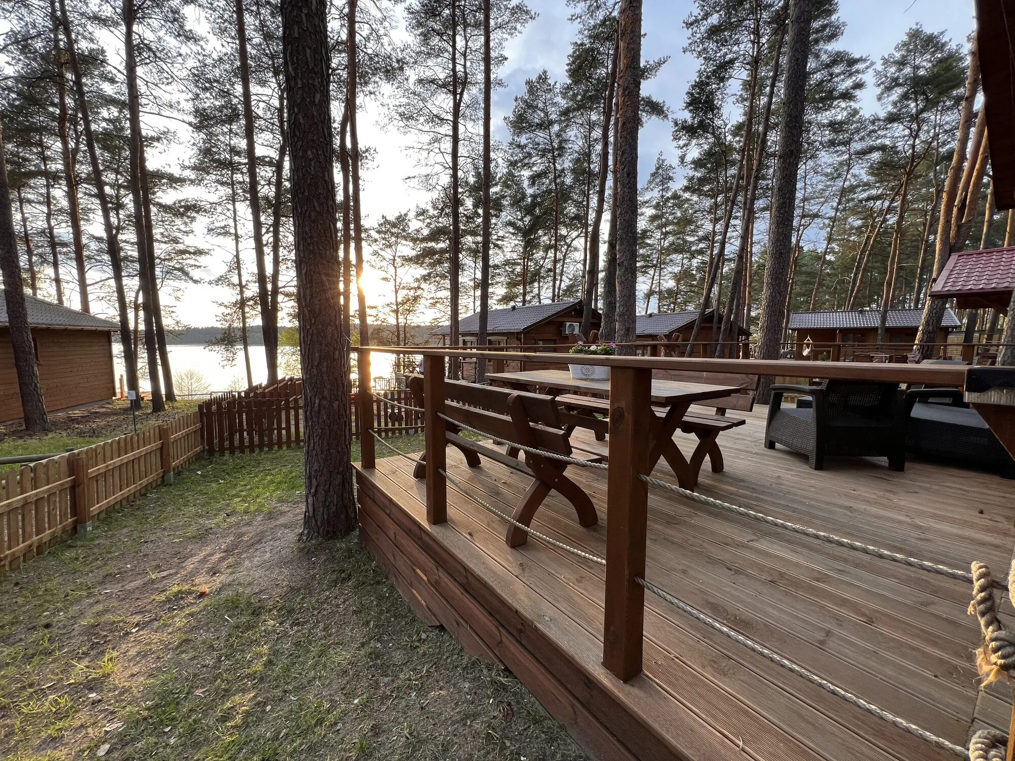 Forest cabin terrace with lounge furniture and a lake view in Borsk