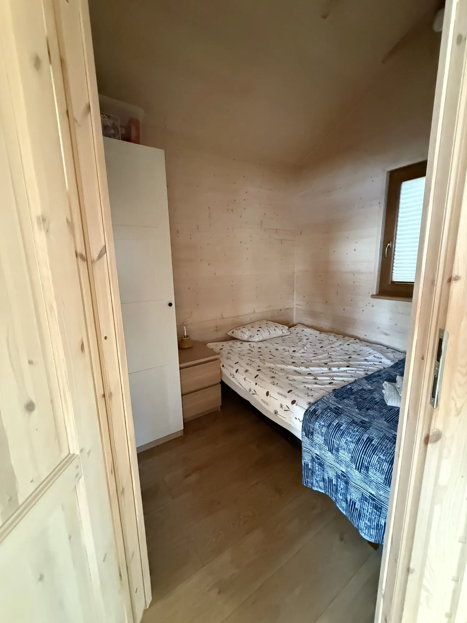 Small bedroom with a bed and wardrobe in the Panorama cabin