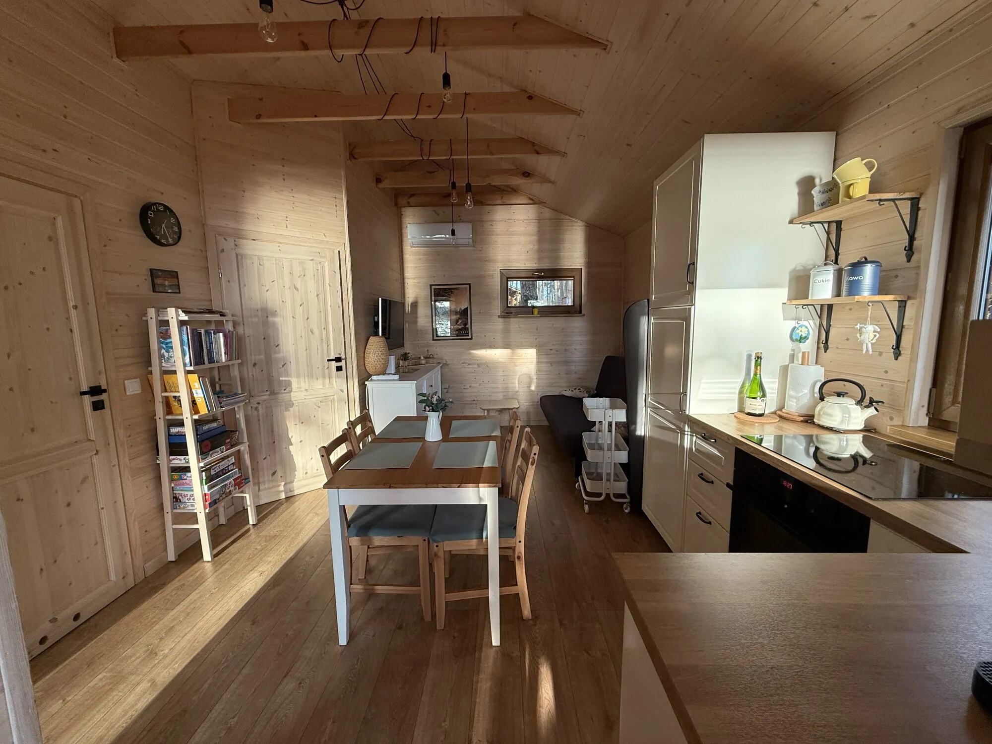 Living room with kitchenette, dining table and board games in the Panorama cabin