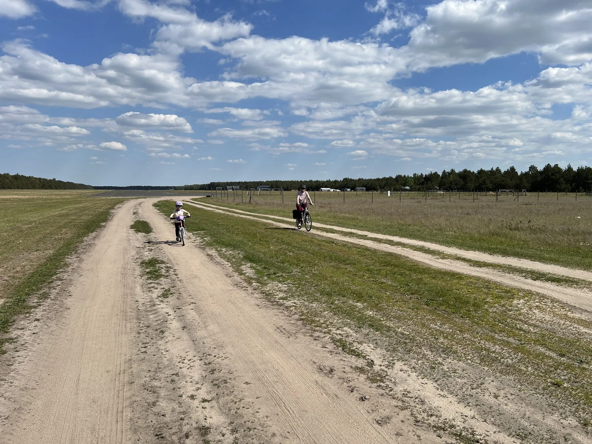 Rowerzyści na szutrowej drodze wśród łąk koło Borska, trasa rowerowa w okolicy Jeziora Wdzydzkiego na Kaszubach